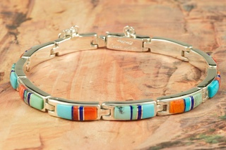 Genuine Sleeping Beauty Turquoise, Spiny Oyster Shell and Black Jade inlaid between ribbons of Sterling Silver. Stunning bracelet featuring precision channel inlay. Designed by Navajo Artist Calvin Begay. Signed by the Artist.